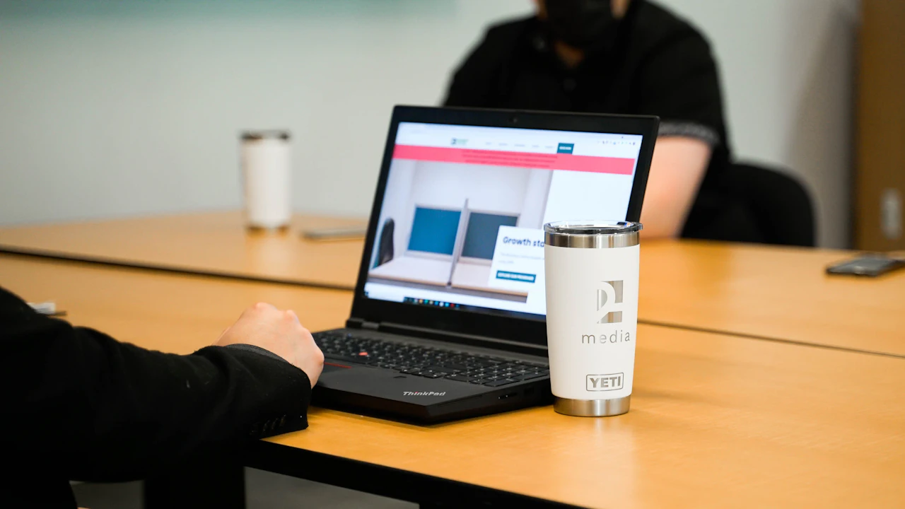 Una laptop sobre una mesa de reuniones de madera